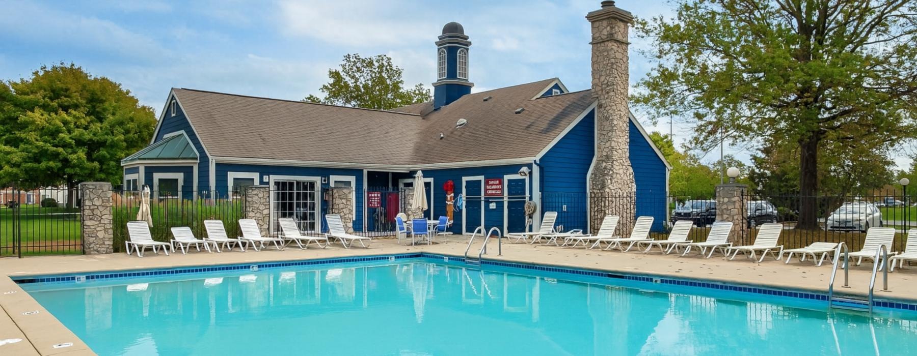 a swimming pool with chairs around it