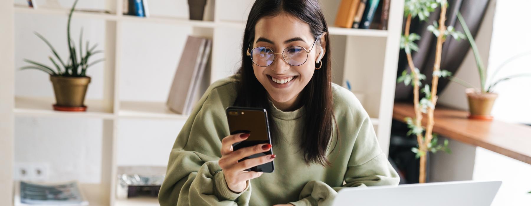 a woman holding a phone on the computer