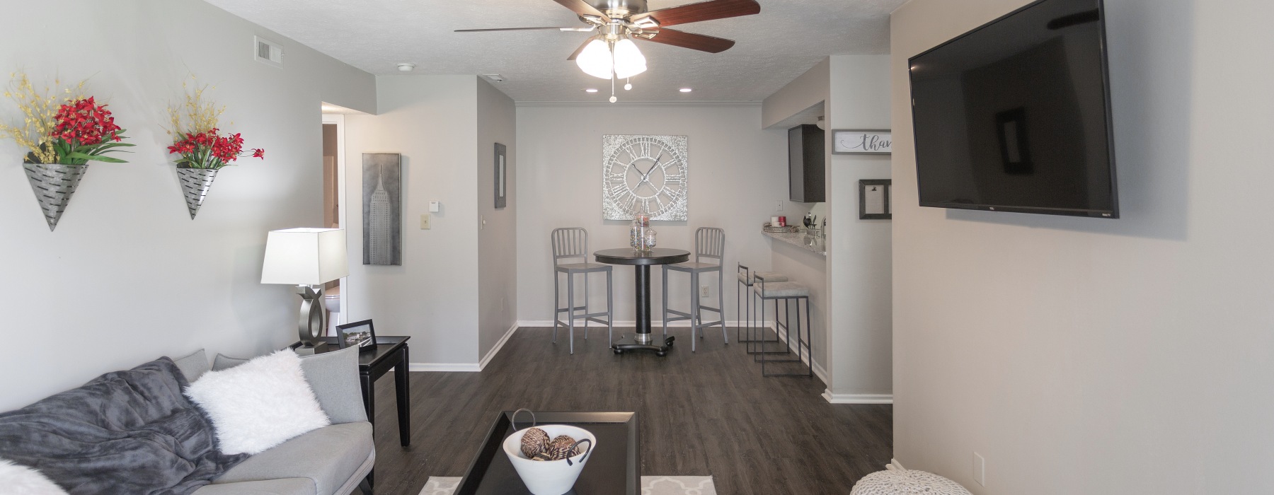 Livingroom with white walls a tv and grey sofa